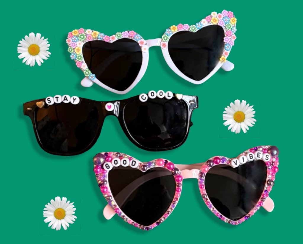 Three pairs of sunglasses decorated with flower beads and letter beads that spell "Stay Cool" and "Good Vibes" made in sunglasses decorating workshop.