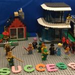 Lego scene with "Scuccess" writen in foamletters being filmed in Lego animation team activity.