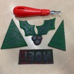 Lino cutting tool next to lino cut stamps in Christmas designs