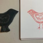 Lino cut stamp in bird design next to lino printed card of same design.
