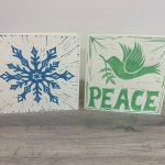 Two lino printed cards in blue snowflake design and green "Peace" dove design on cream coloured cards.