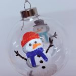 Glass bauble hand painted with snowman design.
