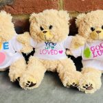Teddy bears in decorated T shirts made in charity team building activity.