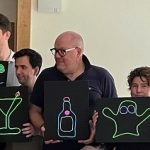 Team holding neon signs in various design made in corporate neon sign making workshop.