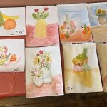 Selection of finished watercolour paintings featuring flowers and fruit.